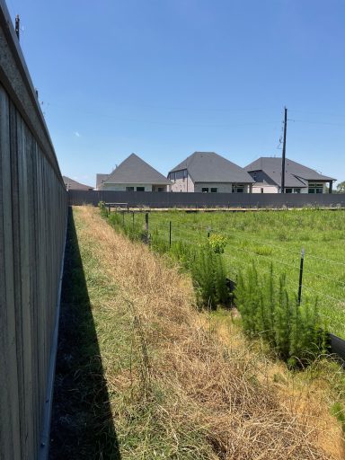 Commercial cedar fence staining project in Hockley TX by LRS Fencing & Gates