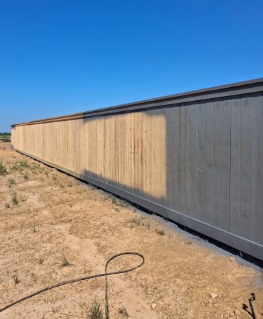 Commercial cedar fence staining project in Hockley TX by LRS Fencing & Gates